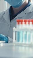 une dévoué scientifique dans une laboratoire manteau et protecteur équipement analyses échantillons dans une moderne laboratoire, en jouant une clé rôle dans le vital recherche et développement de vaccins crucial pour Publique santé video