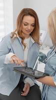 In their appointment, a patient engages with a healthcare professional, reviewing vital health info on a tablet, promoting collaboration and enhancing understanding in their care process video