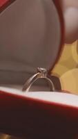 A closeup shows two hands holding a luxurious red velvet ring box with a stunning engagement ring inside, symbolizing love and commitment on Valentines Day, a time for romantic expressions video