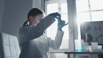 A dedicated scientist in a lab coat and gloves is meticulously preparing a research sample, demonstrating precision and expertise in vaccine development within a modern laboratory video