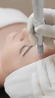 In a soothing clinic, a skilled cosmetologist performs microneedling to enhance skin texture and promote a youthful, radiant appearance for clients seeking to improve their skincare and wellness video