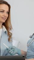 en un ocupado doctores oficina, un alegre paciente discute salud detalles con un experto profesional, ambos utilizando un digital tableta para Toma de notas, mejorando su comunicación y comprensión video