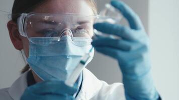 A dedicated scientist in a lab coat, with protective gear, is meticulously preparing a vaccine with a syringe and vial, showcasing exceptional precision in pharmaceutical research and development video