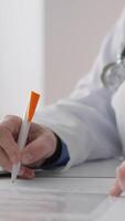 uma dedicada médico profissional dentro uma limpar \ limpo branco casaco escreve notas em uma prancheta e tipos em uma computador portátil, demonstrando uma chave cuidados de saúde documentação processo dentro uma clínico configuração video