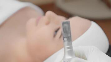A serene moment during a microneedling session at a modern clinic shows a patients face treated with an advanced device, showcasing the precision and dedication in skincare treatments video