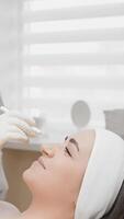 A skilled professional administers botulinum injections to reduce facial wrinkles, with a serene aesthetic setting highlighting the intricacies of these advanced cosmetic procedures video