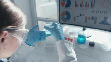 A focused scientist in a lab coat examines a sample in a petri dish, surrounded by colorful test tubes and statistical data on a screen, illustrating vaccine development and scientific research. video