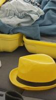 A vibrant yellow suitcase filled with trendy clothes and a stylish hat captures the thrilling anticipation of vacation, embodying the spirit of exploration and wanderlust every traveler feels video