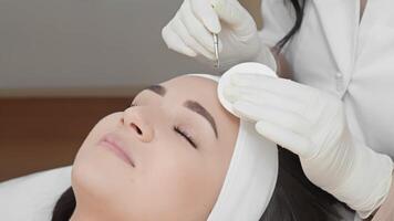 An expert cosmetologist performs a skincare procedure on a client, showcasing advanced techniques and a soothing environment in a professional clinic. Emphasis on skin rejuvenation. video