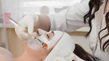 An experienced cosmetologist applies a soothing facial mask to a client, creating a calming moment in a skincare setting focused on relaxation, beauty, and wellness for all skin types video