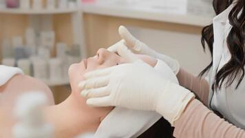A skilled cosmetologist is performing an advanced facial treatment to rejuvenate the skin, creating a calming atmosphere in a modern clinic with the latest technology and techniques video