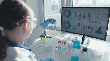 A dedicated scientist in a lab coat studies a test tube and analyzes complex data, advancing research in medicine and vaccine development, driving knowledge and innovation in healthcare video