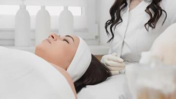 A skilled cosmetologist performs various specialized skin care treatments using the latest techniques in a calm clinic environment, ensuring a delightful experience for the client video