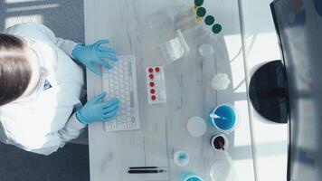 A dedicated scientist in a lab coat operates a keyboard with crucial materials, conducting essential research on vaccine development to enhance global health and improve disease prevention video