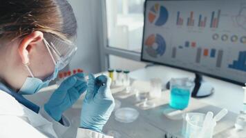 A focused scientist is working in a lab, examining samples and analyzing data on a monitor, highlighting the importance of cuttingedge research in medicine and vaccine development video