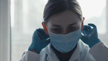 A dedicated scientist in a lab puts on protective gear, including a mask and goggles, showing their commitment to advancing medical research and vaccine development for public health video