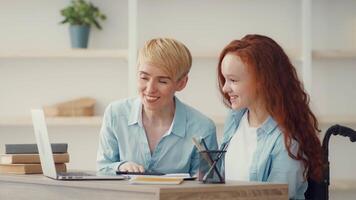 Mother and daughter with different hair colors smile and engage while studying at a well-organized desk, surrounded by books and a green plant during a bright, inviting moment. video