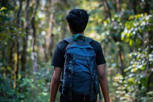A man with a backpack walking through the woods photo