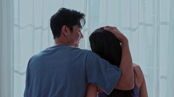 Couple enjoying a moment of intimacy while standing together in a bright room with sheer curtains video