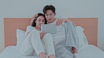 Couple enjoys a joyful moment together while watching entertaining content on a tablet in at home video