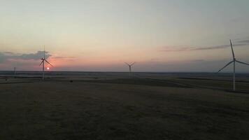 Windmills generating electric power at sunset in a serene windfarm showcasing green energy innovation video