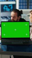Vertical Shareholders in photovoltaics plant analyze market trends on green screen laptop to determine investment strategy. Managers look at data on chroma key notebook, expanding factory production, camera B video