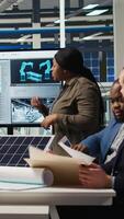 Vertical Shareholders discussing future investment opportunities in sustainable energy manufacturing. Management executives and investors in solar panels plant reviewing solar technology reports, camera A video