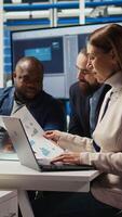 Vertical Factory manager looking over paperwork files, developing business model, expanding production. Employee reading documentation files, integrating automation technology in industrial plant, camera A video