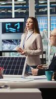 Vertical Executives and investors in photovoltaics plant reviewing solar technology reports, discussing future investment opportunities in renewable energy manufacturing, camera A video