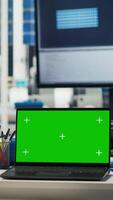 Vertical Chroma key mockup laptop in empty photovoltaics facility used to diagnose malfunctioning systems. Green screen notebook in solar panels manufacturing plant used for alerting in case of downtime video