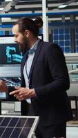 Vertical Scientists in photovoltaics factory experimenting with advanced PV materials to improve solar panel durability and efficiency for long term sustainable energy solutions, camera A video
