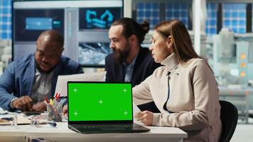 Factory engineers using green screen laptop to refine designs for increased energy output using data. Photovoltaics plant specialists design solar cell prototypes on chroma key notebook, camera B video