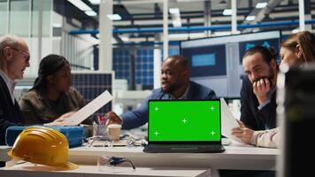 Factory engineers study schematics, refining production layouts using chroma key laptop. Experts outlining industrial plant configurations for prototypes using isolated screen notebook, camera A video