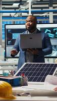 Vertical Teamworking factory colleagues researching new photovoltaics materials. Team of solar panel manufacturing plant researchers developing new solar energy systems prototypes, camera A video