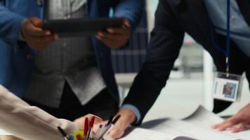Factory engineers study detailed schematics of solar panel assembly lines, refining production layouts using tablet. Industrial plant experts outlining configurations for new prototypes, camera B video