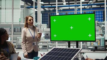 Photovoltaics plant researchers doing meeting, looking at chroma key monitor, evaluating energy production. Experts optimize factory gear energy output, looking at isolated screen display, camera A video