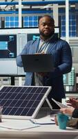 Vertical Portrait of smiling photovoltaics factory scientists experimenting with advanced PV materials to improve solar panel durability. Researchers developing efficient sustainable energy solutions, camera A video