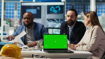 Factory engineers study schematics, refining production layouts using chroma key laptop. Experts outlining industrial plant configurations for prototypes using isolated screen notebook, camera B video