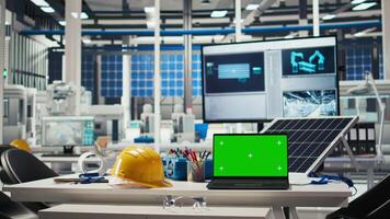 Green screen laptop in photovoltaics facility used for analyzing data and reviewing system metrics. Chroma key notebook overseeing solar panels plant, troubleshooting technical issues video