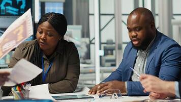 Industrial plant management looking over paperwork and schematics. Factory executives meet with investors to discuss integration of automation technology in production, camera B video