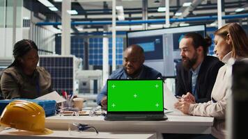 Factory engineers use green screen laptop to check PV materials parameters, improving solar panel durability. Researcher develop efficient sustainable energy solutions using mockup notebook, camera A video