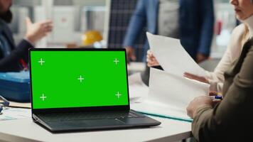 Industrial plant manager typing on green screen laptop, preparing paperwork before business meeting. Factory executive working on pitch for investors using chroma key notebook, automating production video