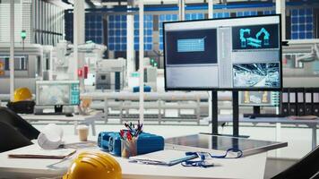 Tracking program on screen in photovoltaics factory used for designing production lines for solar panel assembly facility. Simulation software on monitor in empty solar panels plant video
