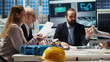 Engineers study detailed schematics of solar panel assembly lines, refining production layouts and component configurations for efficiency, outlining documentation for new prototypes, camera B video