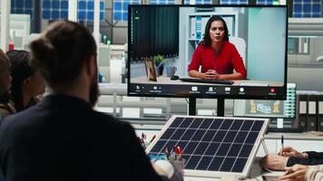 Factory engineers doing online videocall to refine designs for increased energy output using data. Photovoltaics plant specialists design solar cell prototypes in teleconference meeting, camera B video