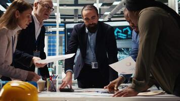 Industrial plant managers and investors analyze technical production data on paperwork documents. Factory management checking manufacturing automation advancements documentation, camera A video