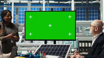 Management executives look at automation strategies for solar panel production scaling on green screen monitor. Businesspeople in factory do financial investments, looking at mockup display, camera B video