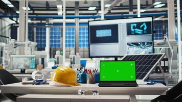 Chroma key mockup laptop in empty photovoltaics facility used to diagnose malfunctioning systems. Green screen notebook in solar panels manufacturing plant used for alerting in case of downtime video