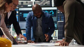 Businesspeople in factory do financial investments, reading documentation files. Management executives look at automation strategies paperwork documents for solar panel production scaling, camera A video