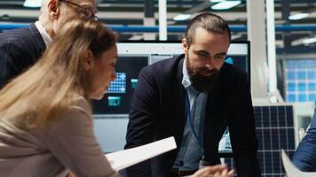 Industrial plant managers and investors analyze technical production data on paperwork documents. Factory management checking manufacturing automation advancements documentation, camera B video